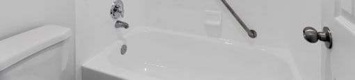 A white bathroom with a tub, shower, and toilet.