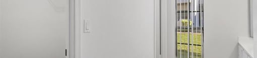 A white room with a door and a window.