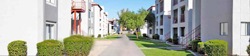 A long, narrow road leads between two rows of apartment buildings.