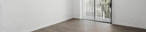 A room with a ceiling fan and a window with blinds.