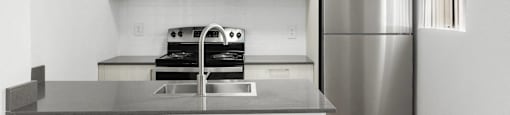 A modern kitchen with a stainless steel refrigerator and a microwave above the stove.