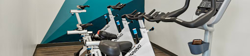 a gym with treadmills and a tv on the wall