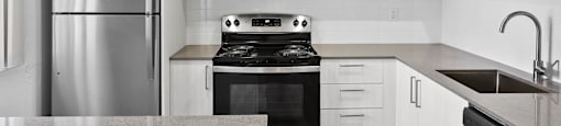 a kitchen with white cabinets and stainless steel appliances