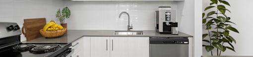 a kitchen with white cabinets and stainless steel appliances and a sink