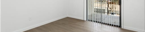 A room with a sliding door leading to a balcony.
