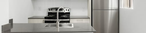 A modern kitchen with a stainless steel refrigerator and a microwave above the stove.