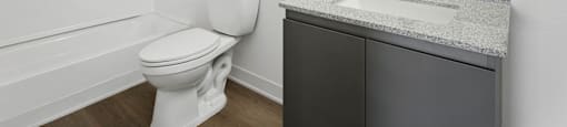 A white toilet sits next to a sink in a bathroom.