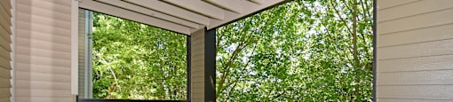 A balcony with a black railing and a view of trees.