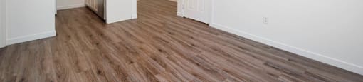 A room with wooden flooring and white walls.