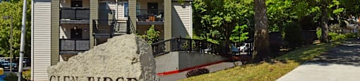 A stone sign that says Glen Ridge in front of apartment buildings.
