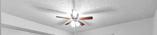 Bedroom with ceiling fan and window at Cedar Grove Apartments in Miami Gardens FL