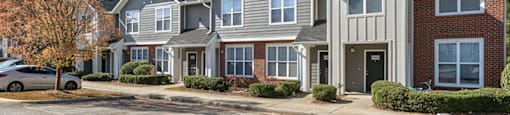 Building exterior and parking lot at Grand Oaks Apartments in Chester VA