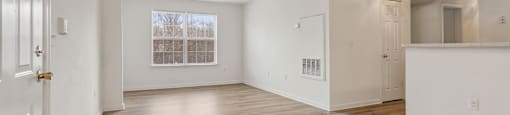 Living room with window and hardwood flooring at England Run Apartments in Fredericksburg VA
