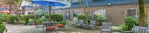 Courtyard with tables and chairs and an umbrella at Boardwalk in Olympia WA