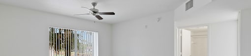 Living room with view of hallway at Brenton at Abbey Park Apartments in West Palm Beach FL
