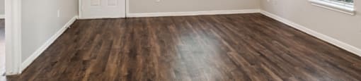 Living room with wood flooring at Park Village Apartments in Conroe TX