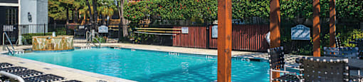 North Dallas TX Apartments - Tivoli Apartments - Relaxing Pool wth Lounge Chairs, Pergola, Table and Chairs