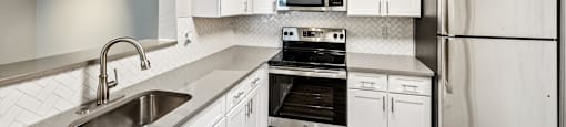 Kitchen with fridge and white cabinets at England Run Apartments in Fredericksburg VA