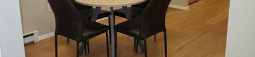 A dining room with a table and chairs.