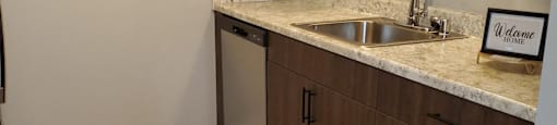 A kitchen with a sink and a rug on the floor.