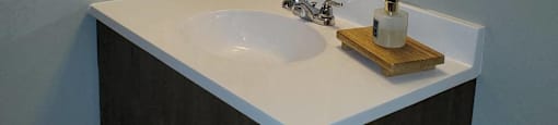 A wall-mounted air conditioner unit is installed above a sink in a bathroom.