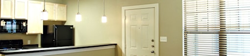 A kitchen area with a counter and cabinets at Centre Place Apartments, Denton, TX 76205