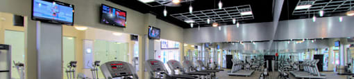 Luxury apartments with huge fitness center with multiple varieties of workout equipment, free weights, yoga and spin rooms at The Lanesborough Apartments in Houston