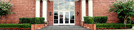 img src="clubhouse.png" alt="red brick exterior of building with glass door and arch"