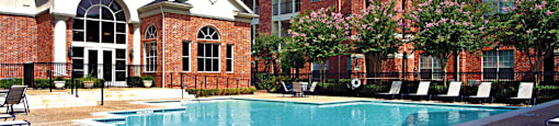 Luxury apartments with large swimming pool, multiple swimming pools, spa, and large sundeck with poolside lounge chairs at The Lanesborough Apartments in Houston