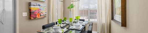 Spacious dining room with wood grain plank flooring, oversized windows, spacious kitchen with white appliances and side by-by-side refrigerators The Lanesborough Apartments in Houston.