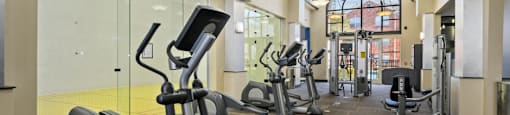 Luxury apartments with huge fitness center with multiple varieties of workout equipment, free weights, yoga and spin rooms at The Lanesborough Apartments in Houston.