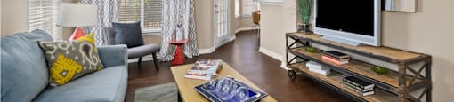 Spacious living room and dining room with 9-foot ceilings, oversized windows, French door and wood grain plank flooring at The Lanesborough Apartments in Houston.