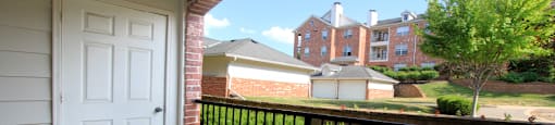 Luxury apartments with red brick exteriors, spacious balcony, and lush landscaping at TurtleCreek apartments in West Des Moines, Iowa