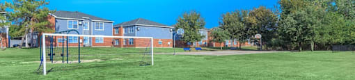 a park with a soccer field and houses in the background at Villas of Sorrento Apartments, Dallas, Texas