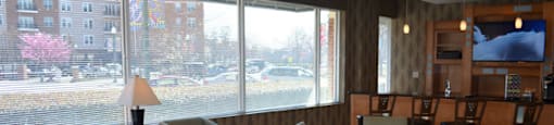 Resident lounge and game room with tables and chairs; bar area with seating; flat screen TV