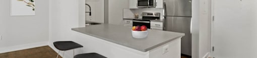 a kitchen with an island and two stools in front of it