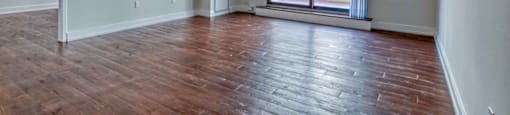 an empty living room with a sliding glass door and hardwood floors