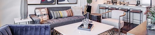 a living room with a kitchen in the background