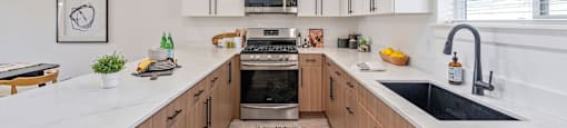 a large kitchen with wooden cabinets and white counter tops