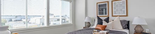 a bedroom with a bed and two windows