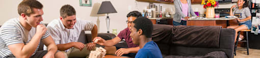 a group of people sitting in a living room playing a video game