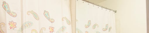 a bathroom with a toilet and a sink and a shower curtain