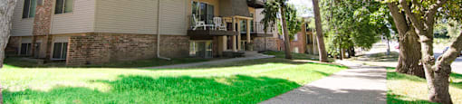 an apartment building with a sidewalk and trees