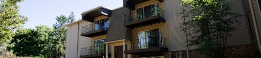 the exterior of an apartment building with a sidewalk and grass