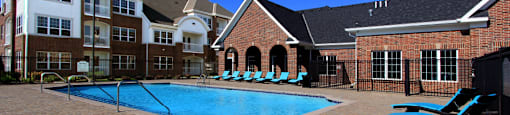 Luxury apartments with swimming pool, poolside lounges, and brick exteriors at Bellemeade Apartments in west Des Moines