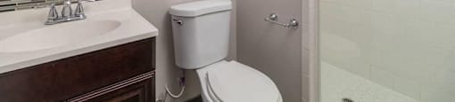 A white toilet sits next to a sink in a bathroom.