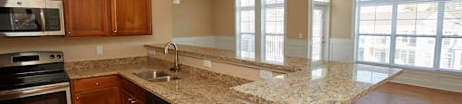 a kitchen with granite counter tops and wooden cabinets