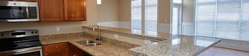a kitchen with granite counter tops and wooden cabinets