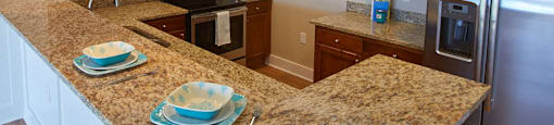 a kitchen with granite counter tops and stainless steel appliances