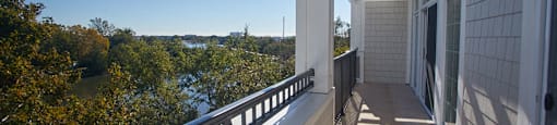 a balcony with a view of a river and trees